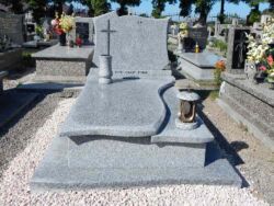 108 Zdjęcie nagrobka w jasnym kamieniu z kamiennym dzbanem oraz zniczem